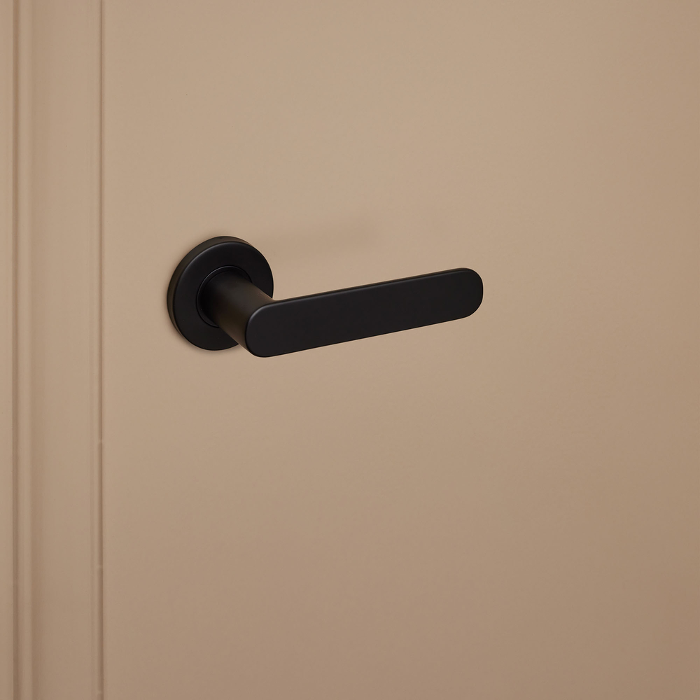 Novara_zwart_rond_rozet_donkerbeige_deur