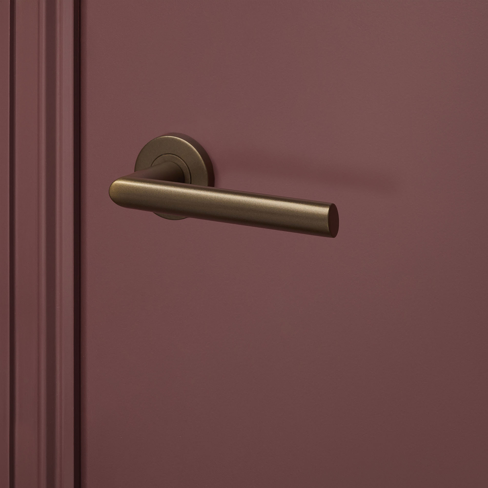 Ragusa_brons_rond_rozet_bordeaux_deur