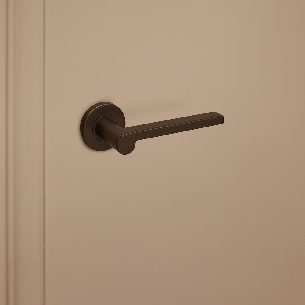 Caserta_brons_rond_rozet_donkerbeige_deur