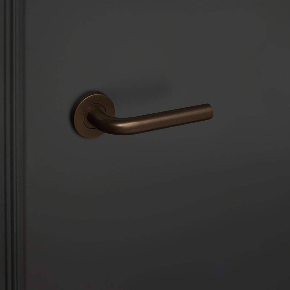 Oristano_brons_rond_rozet_zwarte_deur