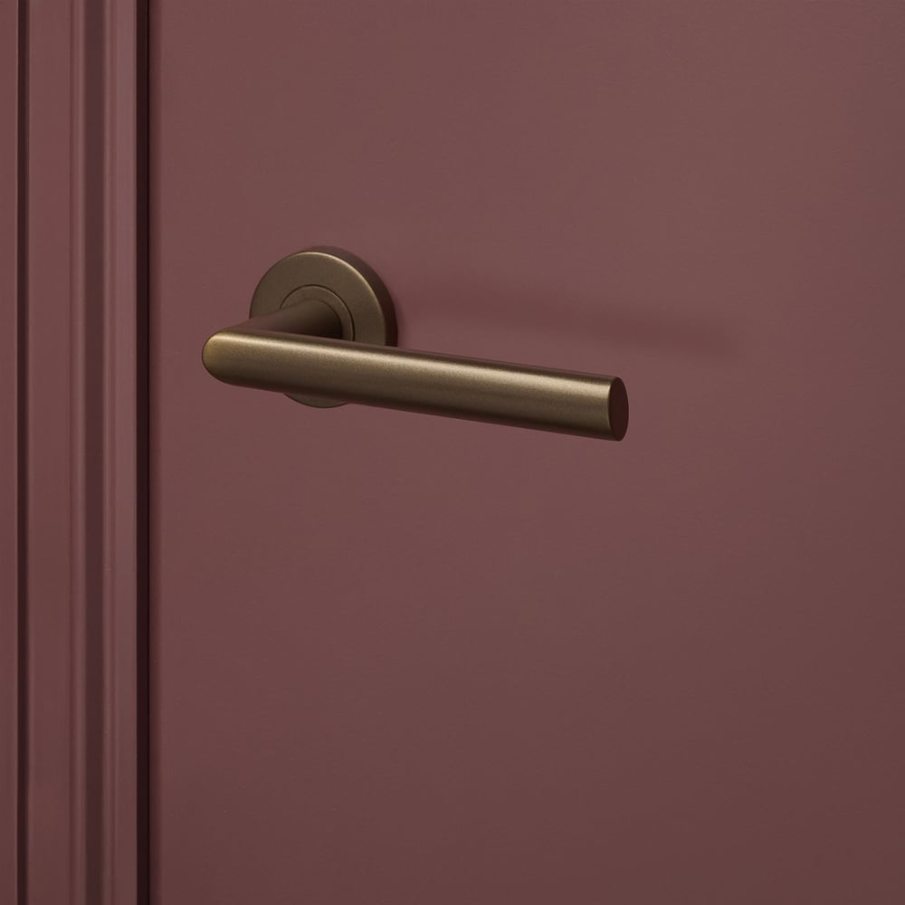 Ragusa_brons_rond_rozet_bordeaux_deur