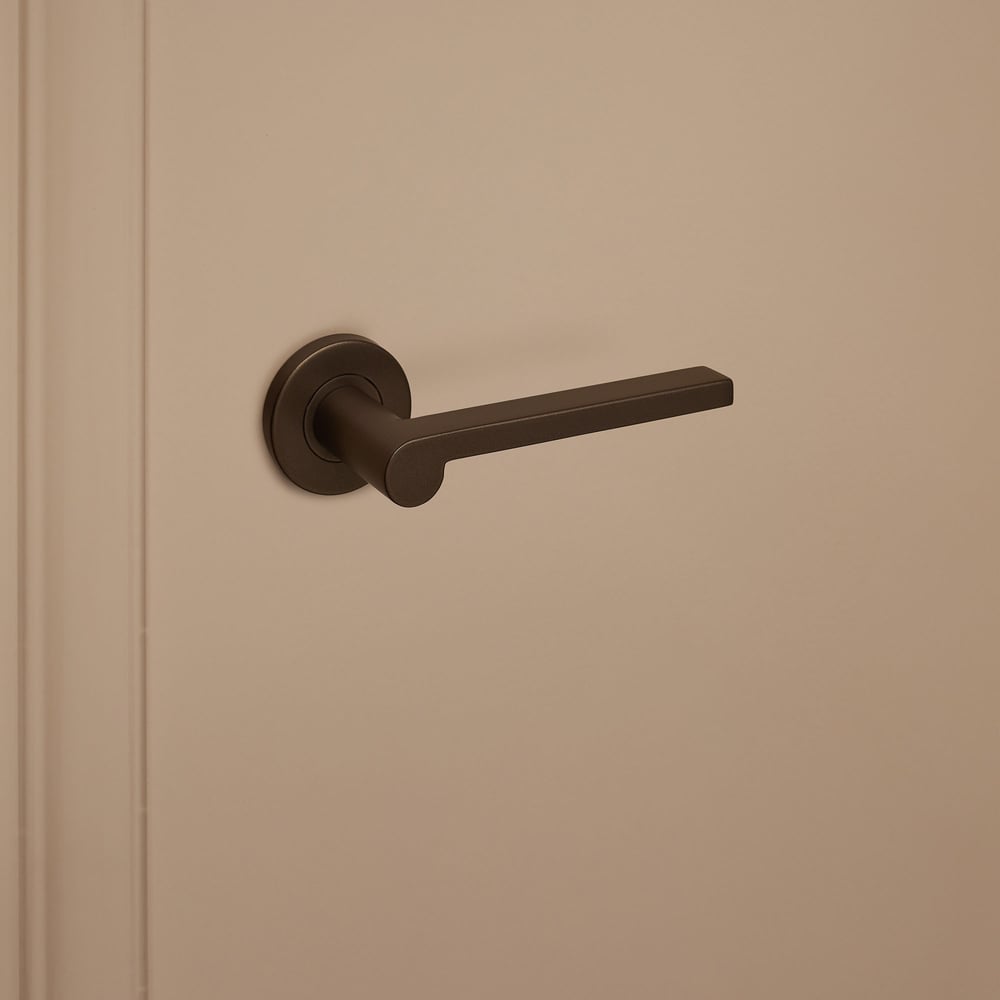 Caserta_brons_rond_rozet_donkerbeige_deur